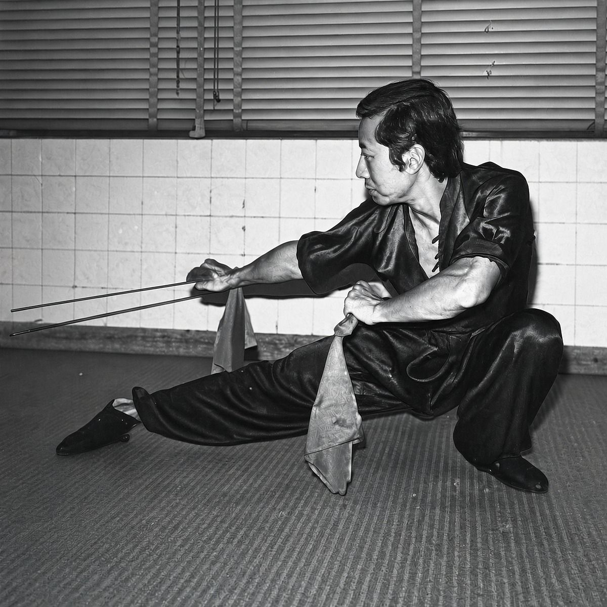 Grandmaster Lam Chun Fai in a low stance with a weapon
